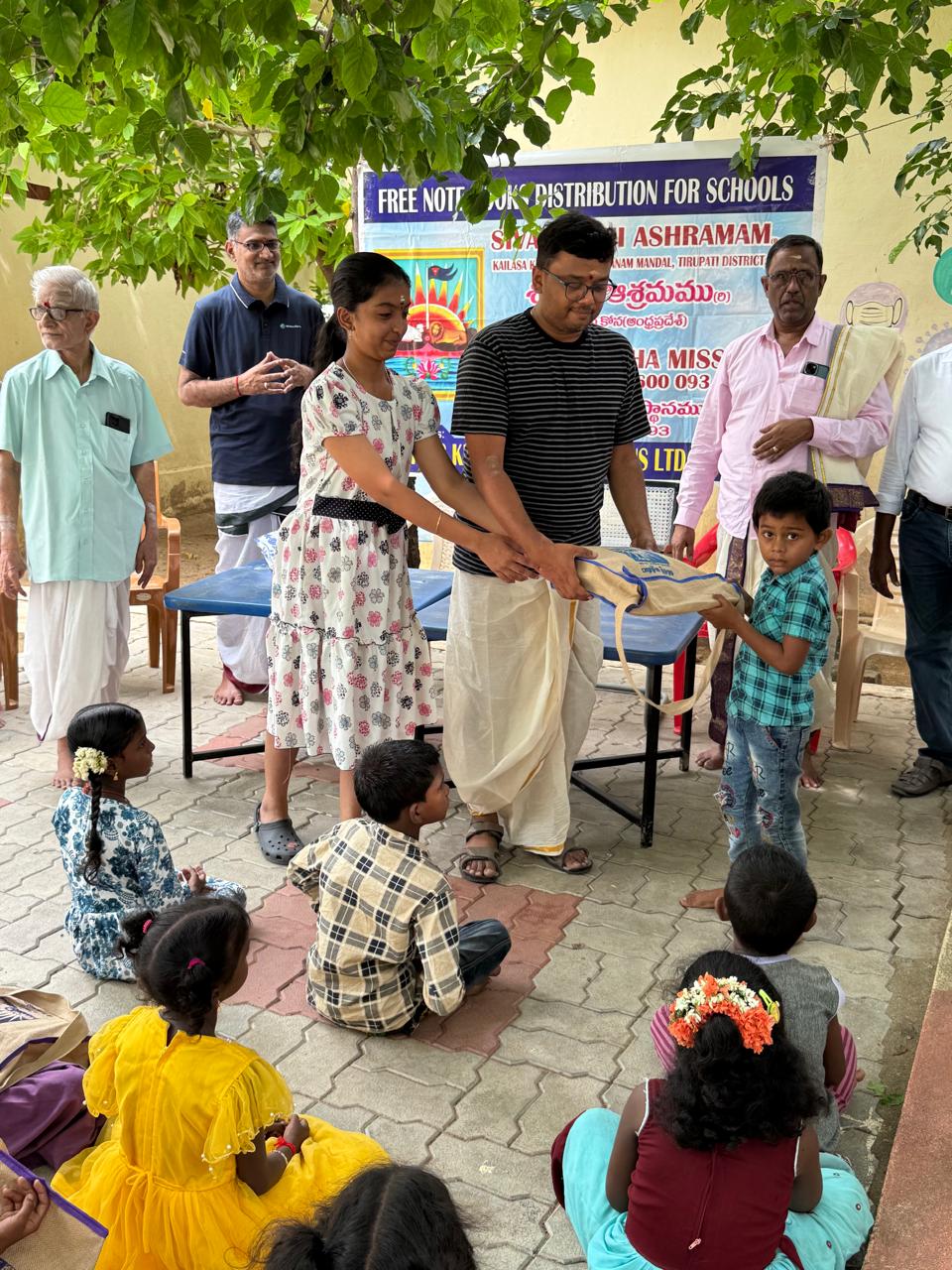 A child receiving a school supply bag while other children watch
